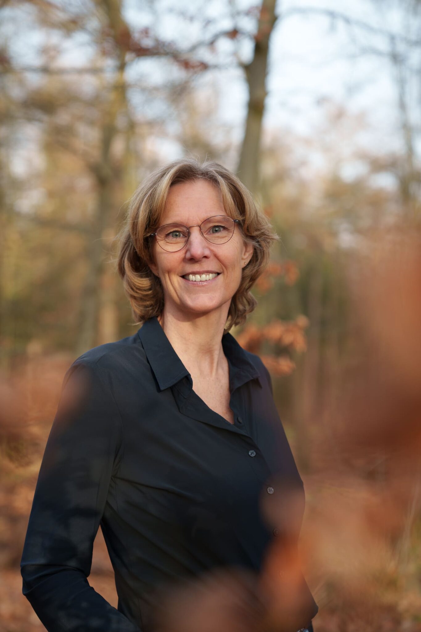 Vrouw in een bosrijke omgeving met herfstkleuren voor Manuele therapie Prinsenbeek.